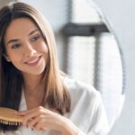 Woman brushing her long healthy hair due to high-quality hair vitamins and supplements can that promote hair growth