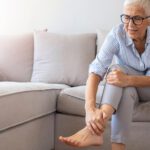 Women sitting on couch suffering from either osteopenia or osteoporosis.