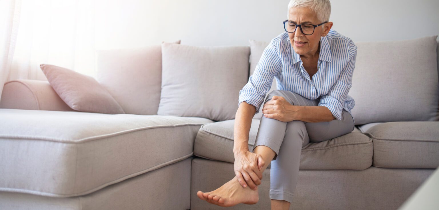 Women sitting on couch suffering from either osteopenia or osteoporosis.